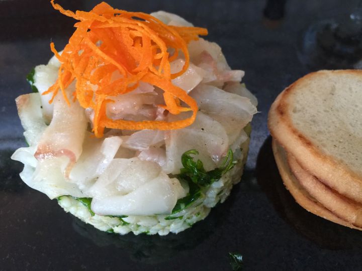 Carpaccio di orata con orzotto servito con olio, crema di sale, rucola fritta e scorza d'arancia  