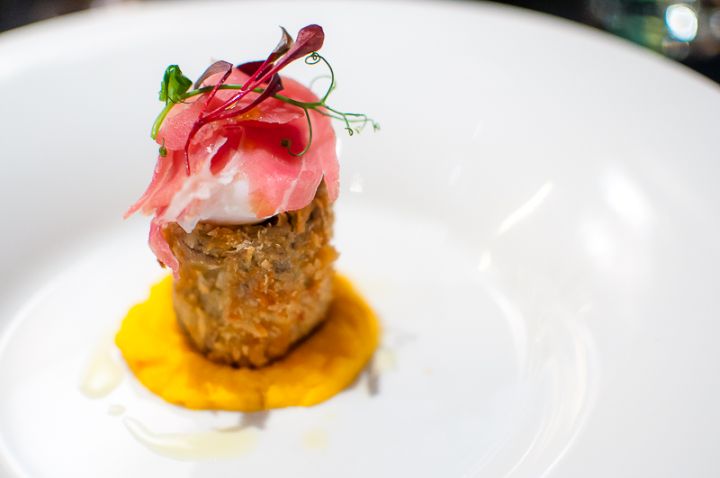 Artichoke with a cooked egg, prociutto di parma on carrot puree, and coriander
