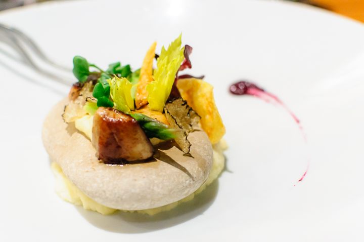 Foie gras on hot stone with black truffels, celery root puree and red grapes.