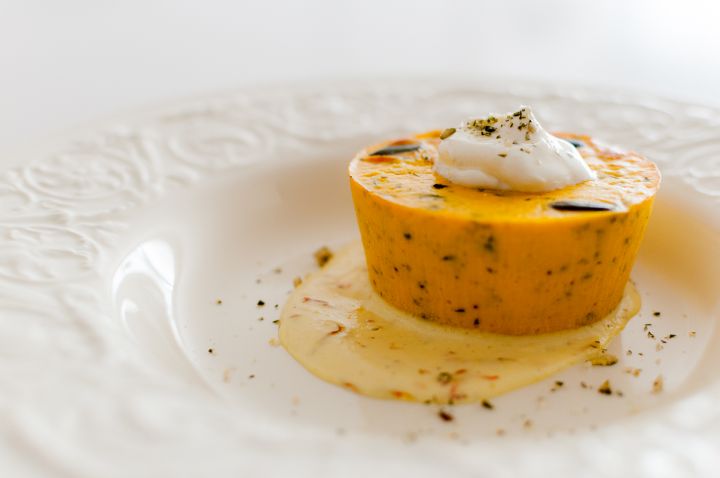 Tortino di zucca su crema di zafferano e ciuffo di formaggio fresco