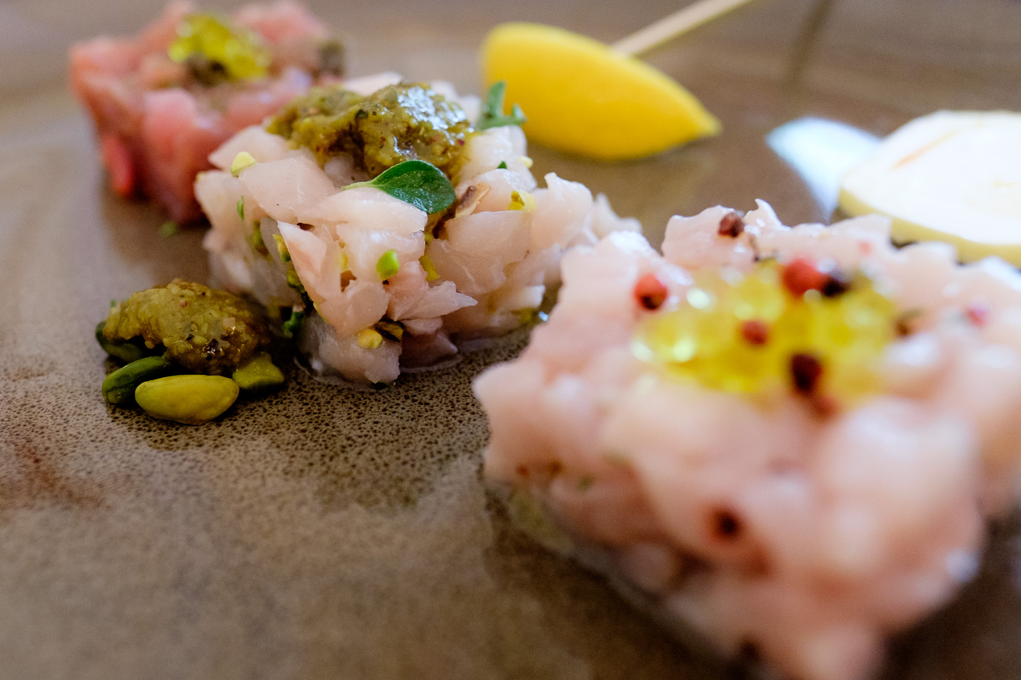 Le tartare: Ricciola, pepe rosa, timo ed olio - Pesce Spada, pistacchio di Bronte e maggiorana - Tonno, capperi, pepe verde e olive